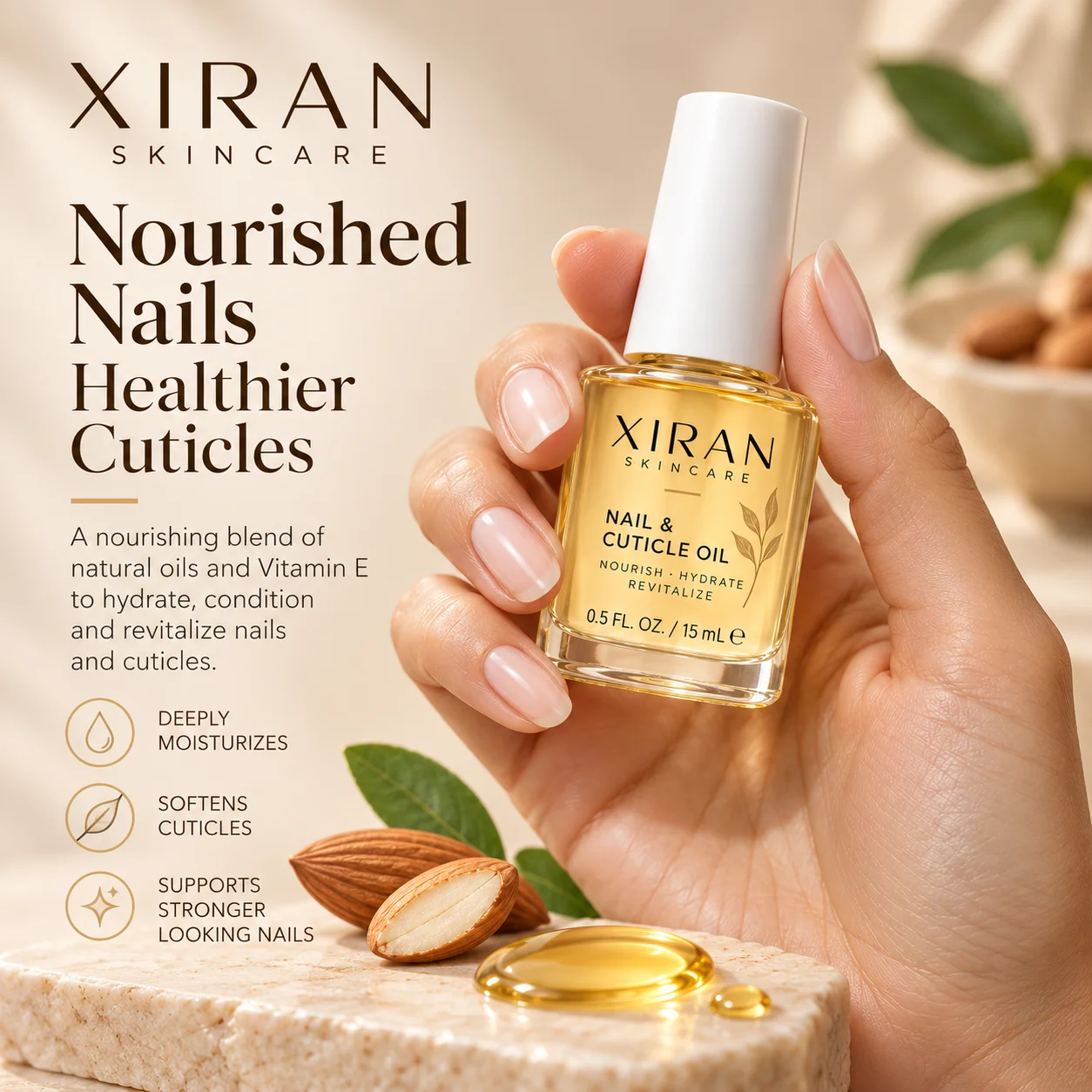 A hand holding a bottle of Xiran Skincare Nail & Cuticle Oil, surrounded by almonds, oil drops, and green leaves on a beige background.